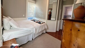 A bedroom with a bed, a mirror, a dresser, and a window with blinds. - Western-Themed & Conveniently-Located Apartment in Tonawanda (Tonawanda)