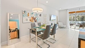 A modern dining area with a glass table, black chairs, and a contemporary pendant light. - Amazing Family House w pvt Pool - 1605 (Almont)
