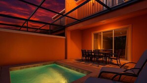 A swimming pool with a patio area, a covered seating area, and a glass door leading to a covered outdoor space. - Amazing Family House w pvt Pool - 1605 (Almont)