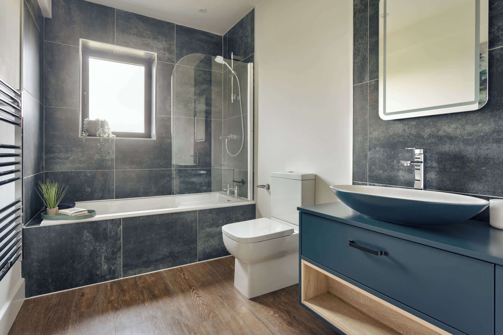 A modern bathroom with a bathtub, toilet, and vanity.