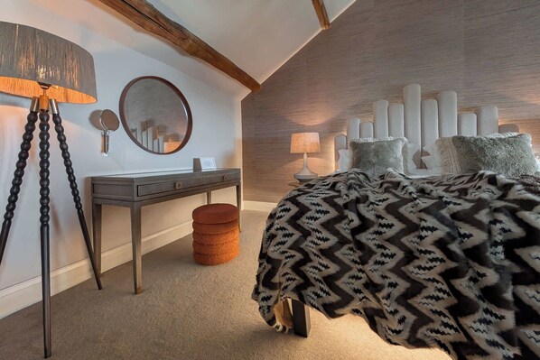 Un dormitorio moderno con cama, mesita de noche, lámpara, espejo y lámpara de pared.