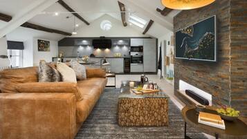 A modern living room with a leather sofa, a coffee table with fruits, and a rustic stone bench.