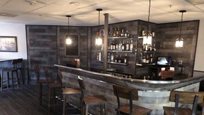 A bar area with a central island, bar stools, and a wine rack. - Enclave Studio – 1 mi to Universal w/ Pool (Orlando)