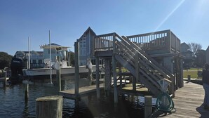 A dock with a wooden staircase leading to a platform, surrounded by water.