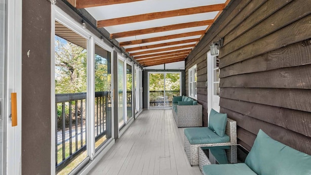 A covered porch with wooden beams, a white floor, and green cushioned seating. - Spacious cabin w/private river, hot tub & fire pit (Harpers Ferry)