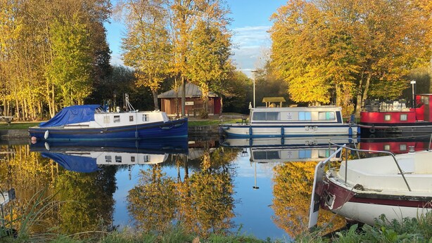 Une rivière paisible où des bateaux sont amarrés le long de la rive.