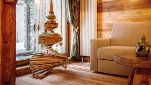 A cozy room with a wooden spiral sculpture, a sofa, and a table.