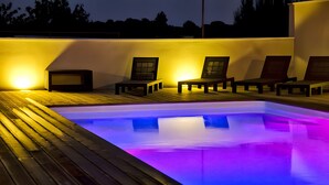A pool with chairs and a table, surrounded by a wooden deck and walls. - Holiday Home “Gîte Genêt - Villa Cassandra” with Shared Pool, Wi-Fi and Air Conditioning (Tavel)
