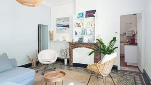 A modern living room with a sofa, chairs, a fireplace, and a bookshelf. - Bright apartment close to the city center (Nîmes)