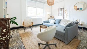 A modern living room with a grey sofa, a white chair, and a hanging light fixture. - Bright apartment close to the city center (Nîmes)