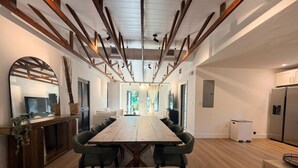 A modern kitchen with a large island, wooden flooring, and built-in appliances. - Modern Rustic Miami Retreat | Tree-Shaded Backyard & Fire Pit | Near Wynwood (Miami)