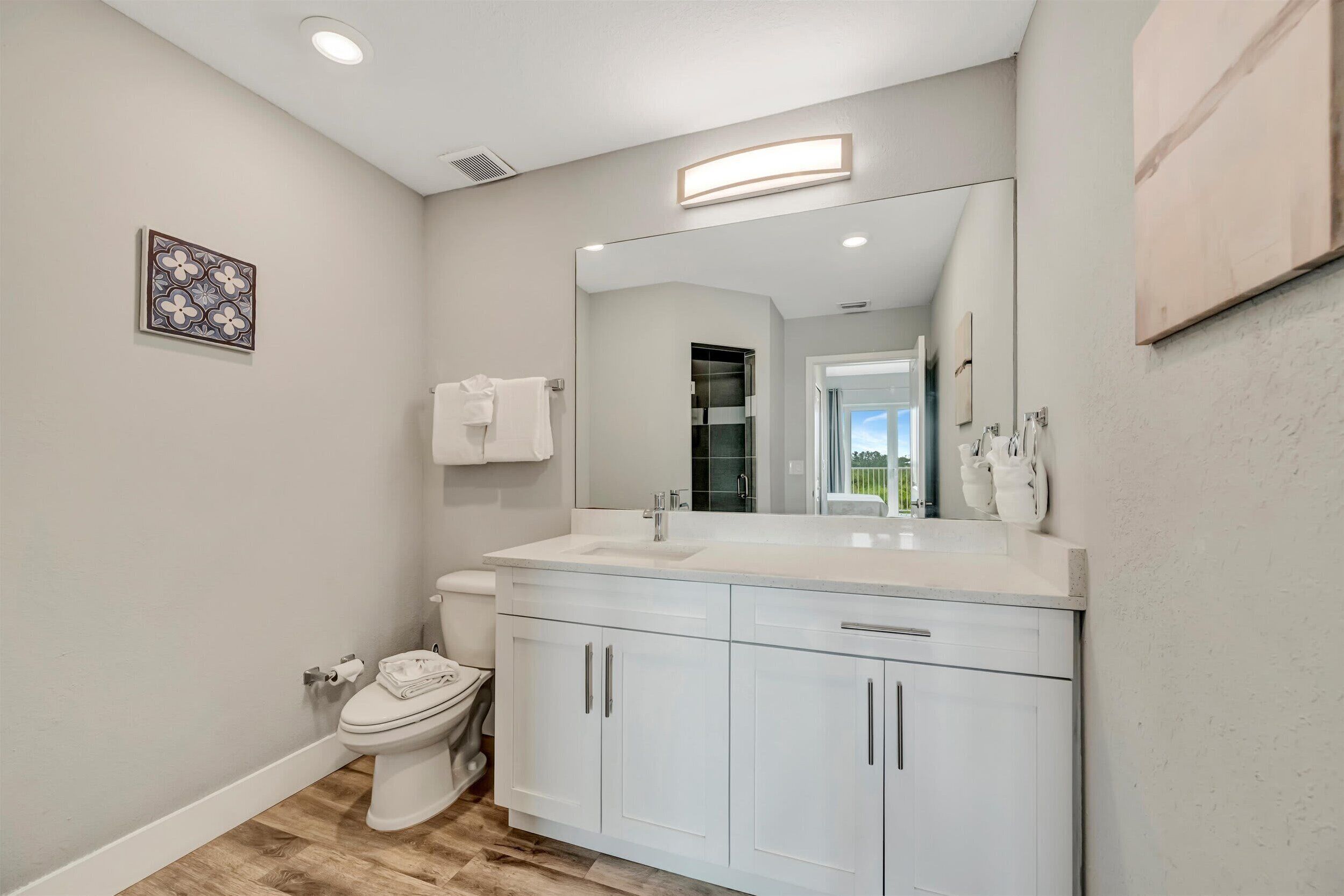 Une salle de bain moderne avec un lavabo, un meuble-lavabo et des toilettes, le tout de couleur blanche.