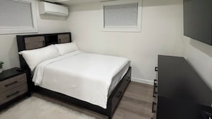 A bedroom with a bed, bedside tables, a dresser, and a ceiling fan.