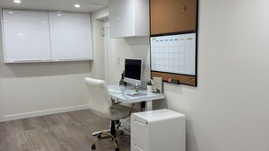 A modern office space with a desk, chair, computer, and filing cabinet.
