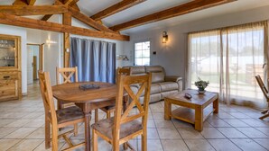 Amplia sala de estar con una mesa de comedor de madera, sillas, un sofá y una mesa de centro.