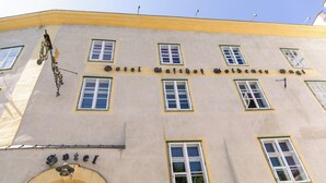 A building with the sign "Hotel Gaißach Gaißener Guel." It features multiple windows with white frames and a yellow trim. - Goldener Engl (Hall In Tirol)