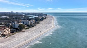 Aerial view showcasing the pristine beachfront stretching along the coastline, with residential buildings nestled among lush greenery near the waterfront area. - FREE Boat Parking! Waterfront Condo & Pet Friendly (Indian Rocks Beach)