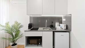 A compact kitchenette with a microwave, toaster, and coffee maker. - GuestReady The 7 Seas - 'Caribbean Sea' 1D (Porto)