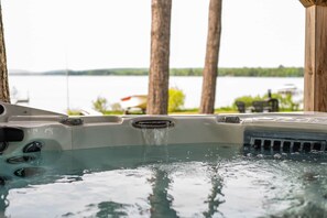A hot tub with a view of a lake and boats in the background.