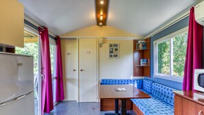 A compact kitchenette with a refrigerator, a microwave, and a small table.
