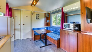 A compact kitchen with a built-in bench, a microwave, and a refrigerator.