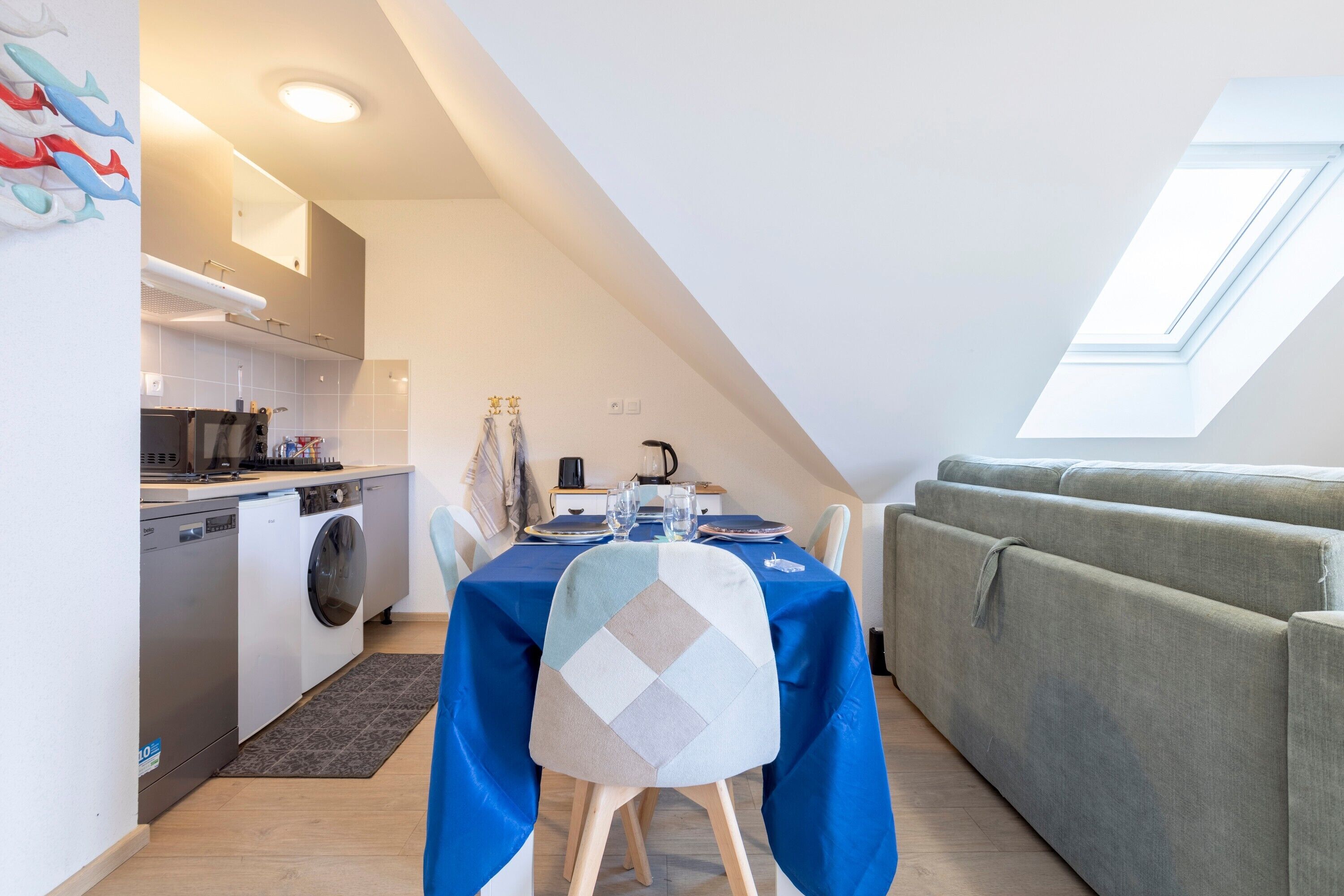 Espai habitable reduït amb zona de menjador, petita cuina i sofà.