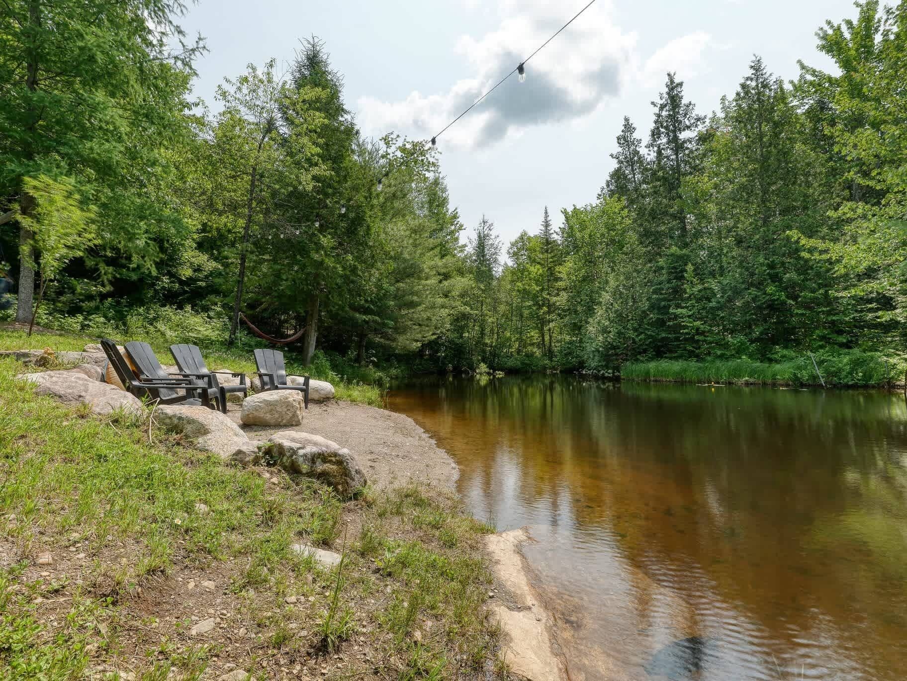 A lakeside setting with outdoor seating and a hammock.
