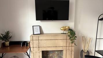 A modern living room with a fireplace, a mounted TV, and a wooden floor.