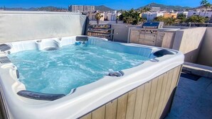 Ein Whirlpool auf einem Dach mit Blick auf die Stadt.