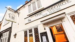 O George Ale House com fachada tradicional, incluindo uma placa e uma janela com cardápio.