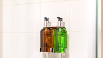 Two bottles of Cole & Lewis shampoo and conditioner mounted on a wall.