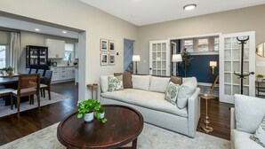 Un salon moderne avec un canapé, une table basse et un coin repas.