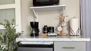 A compact kitchen with a microwave, coffee maker, and a small refrigerator. - Cozy Retreat in Orlando. (Orlando)
