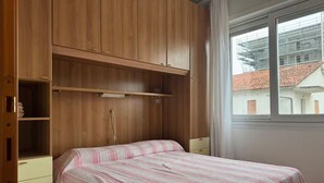 A bedroom with a bed, wooden wardrobe, and a window with a view of buildings. - Guest Access🌊 Jesolo – Condominio Venezia Apartment✨ Perfect for Families and Groups, Just Steps from the Sea!Welcome to your ideal retreat in Jesolo, where golden sand and crystal-clear sea await you less than 1 minute from your door! 🌅 If you (Lido di Jesolo)