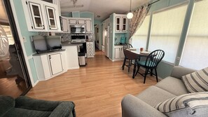 A compact living space with a kitchenette, dining area, and seating. - Spacious 1-bedroom bungalow in Sarasota with AC, resort amenities included. (Sarasota)