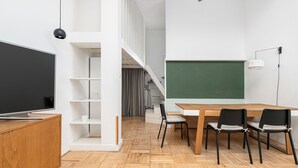 A modern classroom with a large blackboard, wooden desks, and chairs. - RentPlanet - Apartament Krucza (Warsaw)