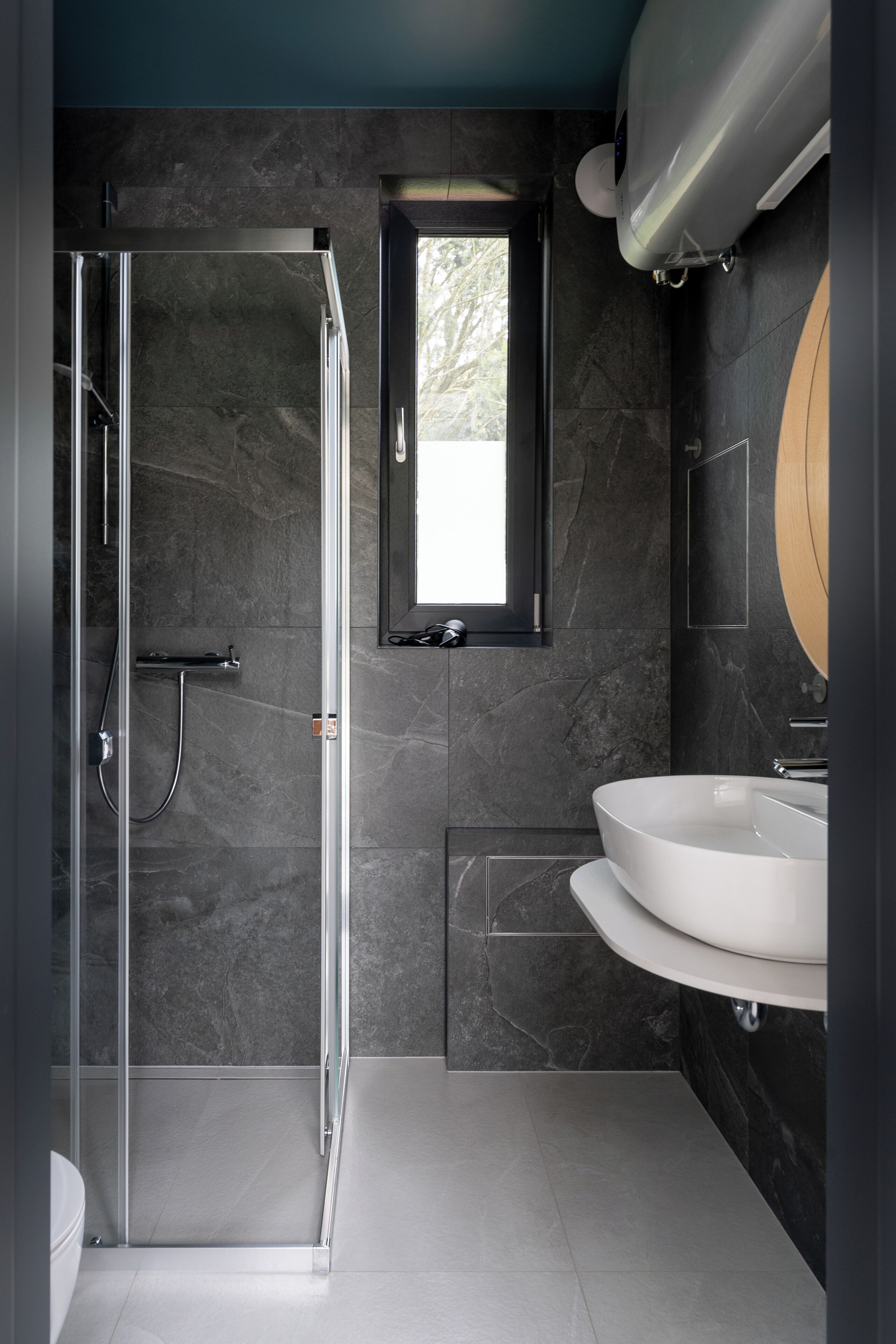Un baño moderno con cabina de ducha de vidrio, un lavamanos y un espejo.