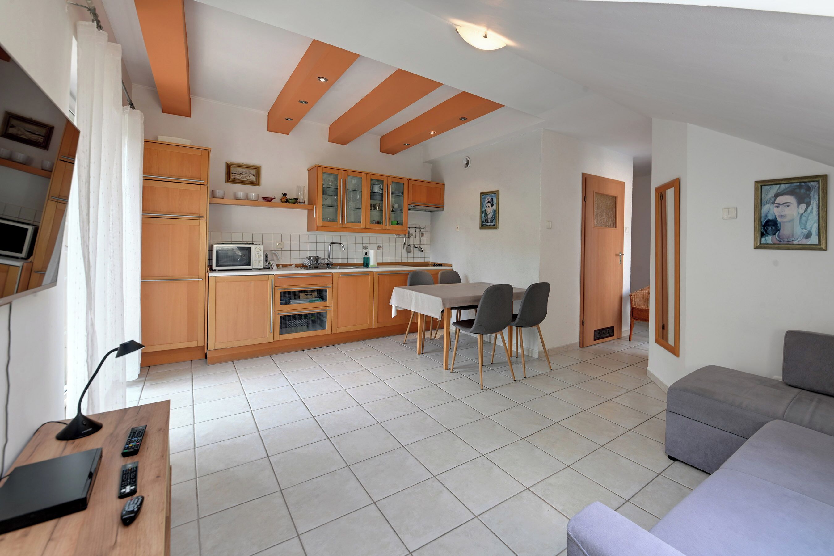 A compact living space with a kitchenette, dining area, and a sofa.