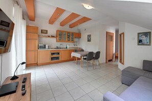 A compact living space with a kitchenette, dining area, and a sofa. - RentPlanet - Osiedle Huty (Szklarska Poręba)