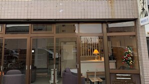 Ein Gebäude mit einem Schild für Traveler's Inn, das einen großen Glasfront-Eingang mit Innenbestuhlung zeigt.