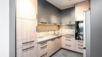 Eine moderne Küche mit Holzausstattung, Granitarbeitsplatten und einem eingebauten Backofen.
