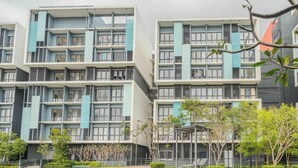 A multi-story residential building with balconies, a covered outdoor seating area, and surrounding greenery. - Core Soho Suites Sepang by The Stay Hub (Sepang)