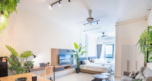 Ein modernes Hotelzimmer mit Bett, Schreibtisch, Laptop, Fernseher und Balkon mit Blick.
