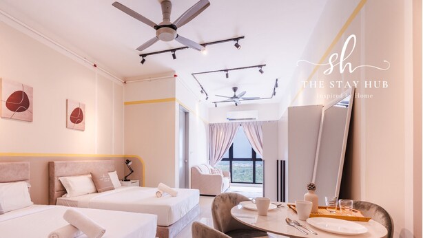 A hotel room with two beds, a dining table with chairs, a ceiling fan, and artwork on the walls. - Core Soho Suites Sepang by The Stay Hub (Sepang)