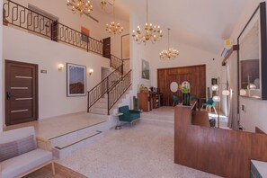 A hotel lobby with a staircase, seating area, and a reception desk. - Abasolo ClubHouse  (La Paz)