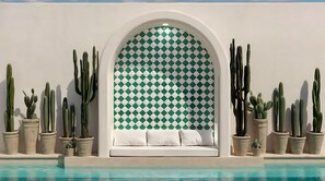 Una piscina al aire libre, sombrillas, sillones reclinables de piscina