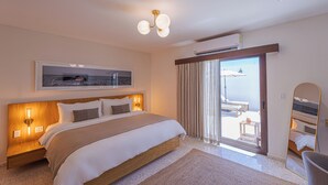 Habitación de hotel con una cama grande, una lámpara en el techo, aire acondicionado instalado y un ventanal corredero que da a un área exterior.
