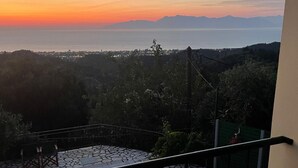 A balcony with a pool, overlooking a scenic view of the sea and distant mountains during sunset. - Villa Victoria (Corfu)