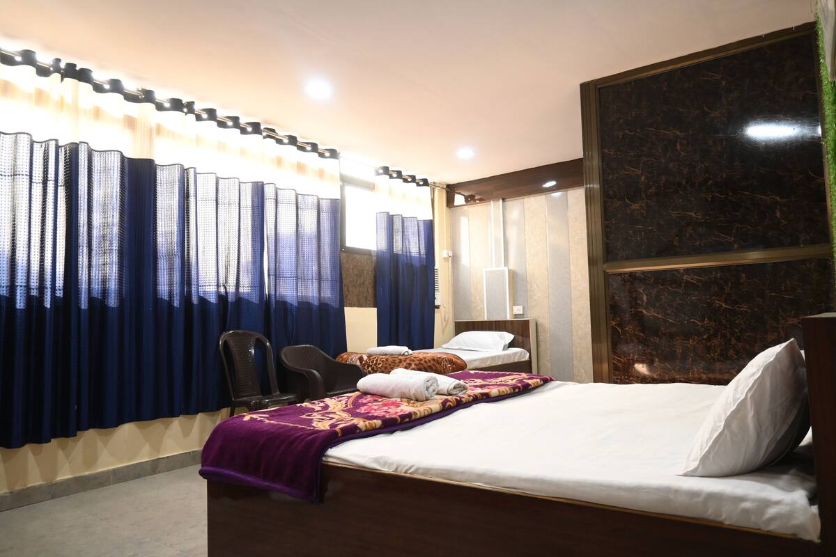 Une chambre d’hôtel avec un lit, une chaise, un bureau et un grand miroir.