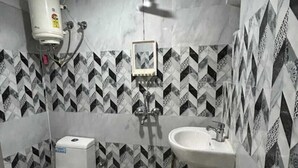 Un baño con inodoro, bidé y lavamanos, todo con accesorios blancos.